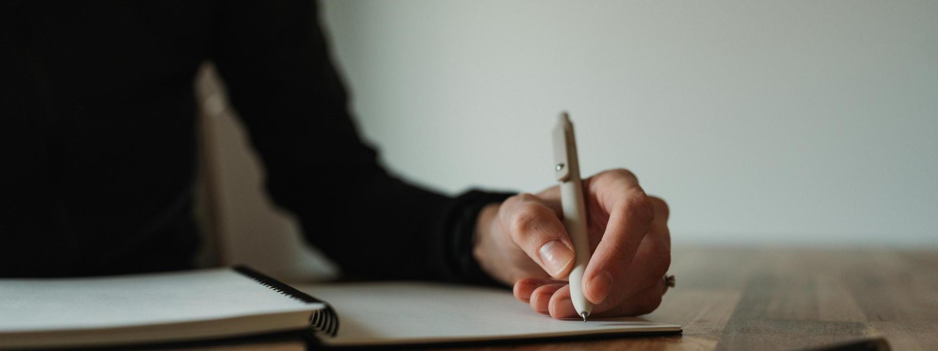 Someone writing on desk